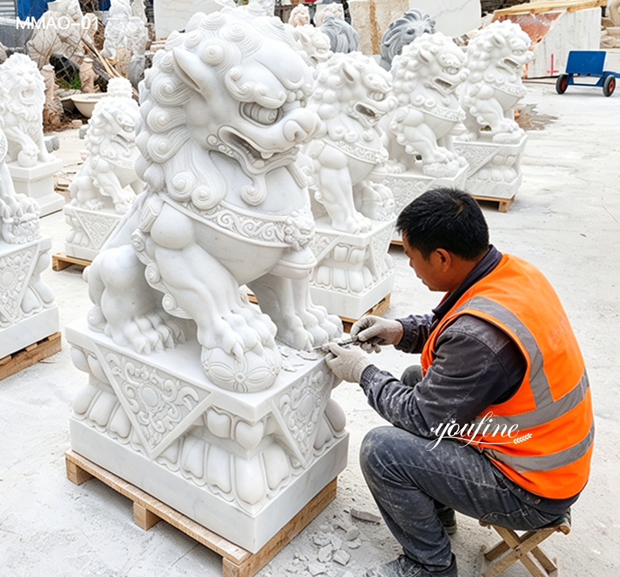 Artisan hand carving white marble Chinese guardian lion foo dog statue, showing detailed craftsmanship during production