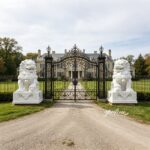 Pair of white marble Chinese foo dog statues at luxury villa entrance, large hand carved stone guardian lion sculptures for driveway gate
