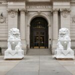 White marble Chinese foo dog guardian lion statue pair at commercial building entrance, weather-resistant stone lion sculptures