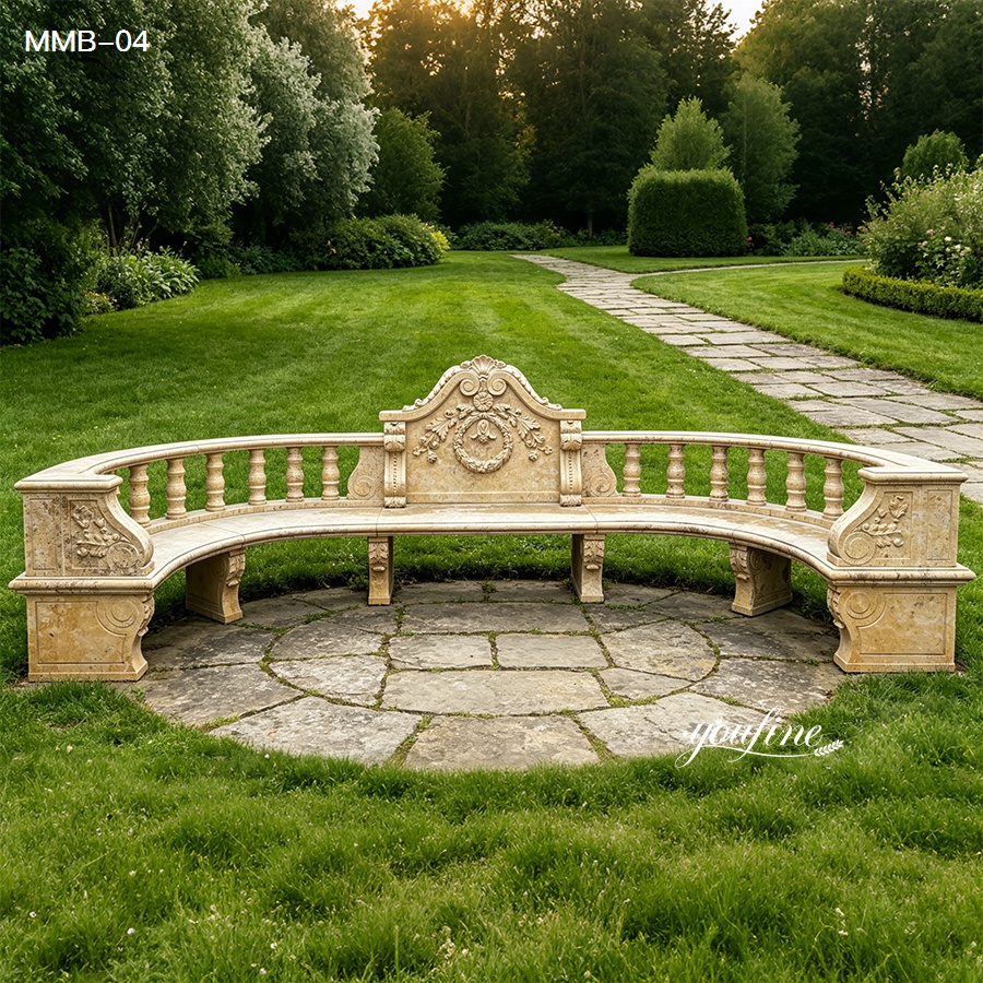 Beige travertine marble garden bench with curved design placed on a stone patio in a landscaped garden