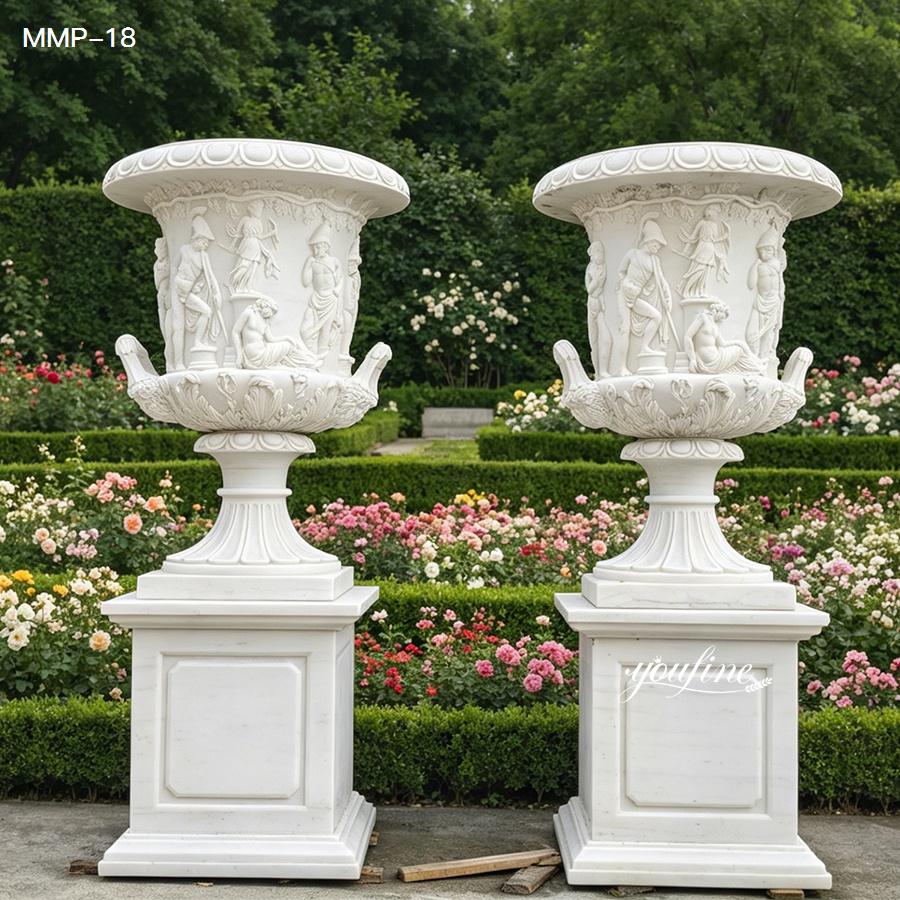 Pair of large carved marble plant pots with pedestal in garden