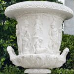 Detailed view of hand-carved relief sculpture on marble planter