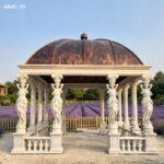 Daytime view of the white marble gazebo with caryatid columns set in a lavender garden.