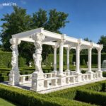 Marble column garden stone gazebo set in a formal garden, showcasing the symmetrical design and marble craftsmanship.