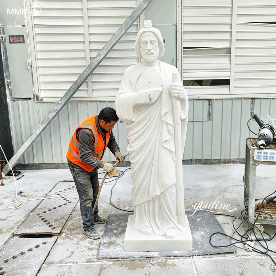 Skilled artisan polishing a hand-carved marble St. Jude statue in the YouFine workshop, showcasing the careful craftsmanship of religious sculpture.