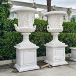 Outdoor white marble planter urn with classical relief sculpture
