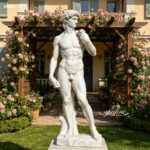 Natural marble David statue placed in romantic garden with flowers