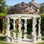 elegant round garden gazebo made of polished white marble, featuring detailed caryatid statue columns and an openwork copper dome, perfect for villa garden landscaping