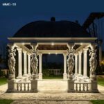Night view of the square white marble gazebo with soft lighting highlighting the caryatid columns and copper roof.