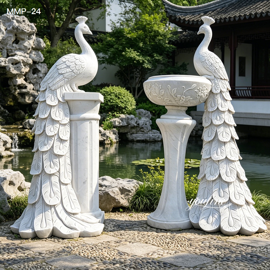 Outdoor white marble peacock planter statue beside a garden pond and rocks