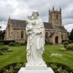 Pure white marble St Joseph statue with the infant Jesus, standing in a church courtyard, perfect for outdoor religious decoration.