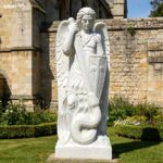 Large outdoor marble St Michael the Archangel statue, handcrafted with exquisite details in a historic church garden