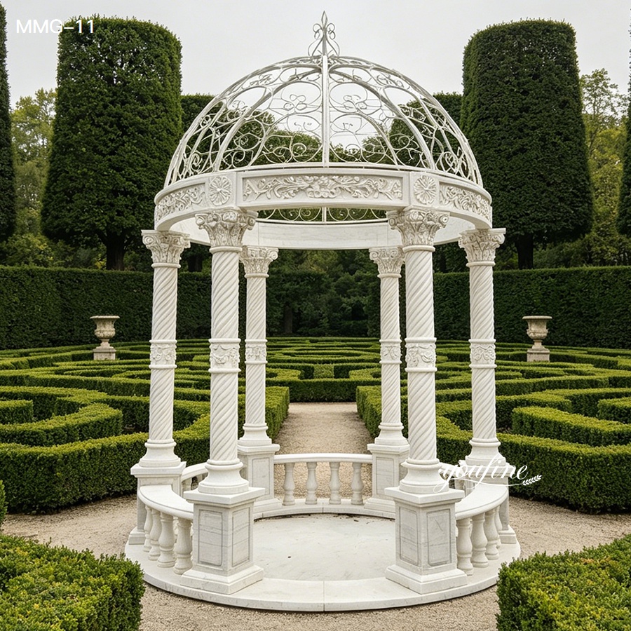 Full view of round white marble column gazebo with white iron dome, set in a formal hedge maze garden