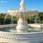 one tier white marble fountain with water flow in outdoor garden