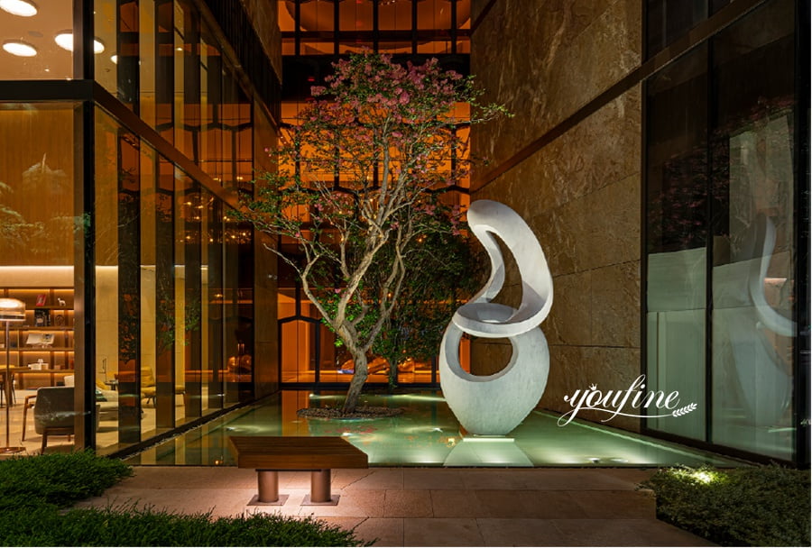 Abstract flowing white marble sculpture in modern indoor courtyard