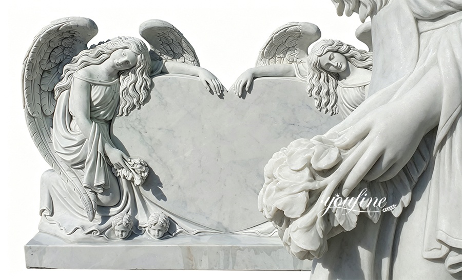 Close-up of carved angel holding flowers on marble heart headstone