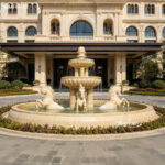 Beige marble fountain with horses at a hotel entrance, matching the classical building facade.