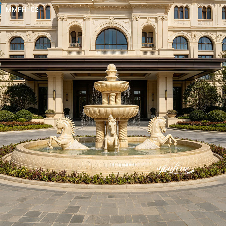 Beige marble fountain with horses at a hotel entrance, matching the classical building facade.