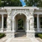 Ornate white marble door frame with angel reliefs and classical lady statues for villa entrance