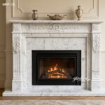 Classic white Carrara marble fireplace surround with floral carvings in a neutral-toned living room