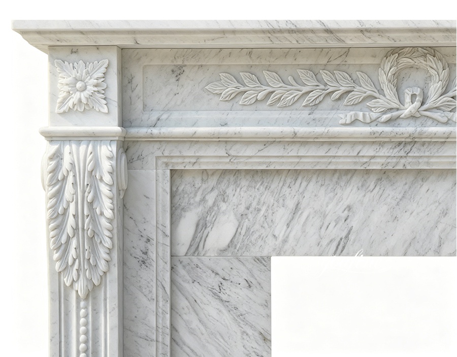 Close-up view of hand-carved laurel leaf and floral details on a white Carrara marble fireplace surround