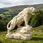 Egyptian beige marble tiger sculpture standing on stone base in mountain landscape