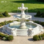 Hand carved two tiered marble water fountain placed in a luxury garden setting