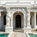 White marble door surround with detailed angel and lady statues, custom carved marble doorway