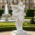 Elegant white marble angel statue with flowing dress and wings displayed in a formal garden setting