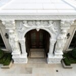 White marble door frame with angel carvings and lady statues, classical European style villa entrance