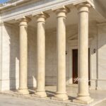 High quality marble pillars for sale, evenly spaced tapered columns forming a grand portico entrance for a building