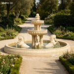 Large beige marble fountain with horses in a formal French garden, surrounded by manicured greenery.