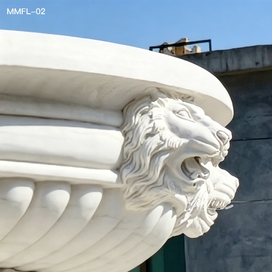 Close-up of lion head spout where water flows from the mouth on a marble outdoor fountain.