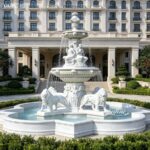 Front view of a large outdoor marble lion fountain installed in a luxury courtyard.