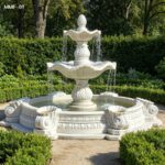 hand carved marble fountain with layered water effect in garden
