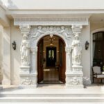 Classical white marble door surround with hand-carved lady statues and cherub details for luxury home