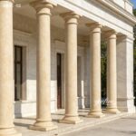 Polished beige marble pillars for sale, symmetrical tapered columns creating a balanced and elegant classical architectural facade