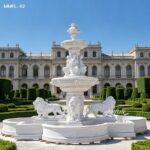 Side angle of a large marble lion water fountain outdoor with tiered structure.