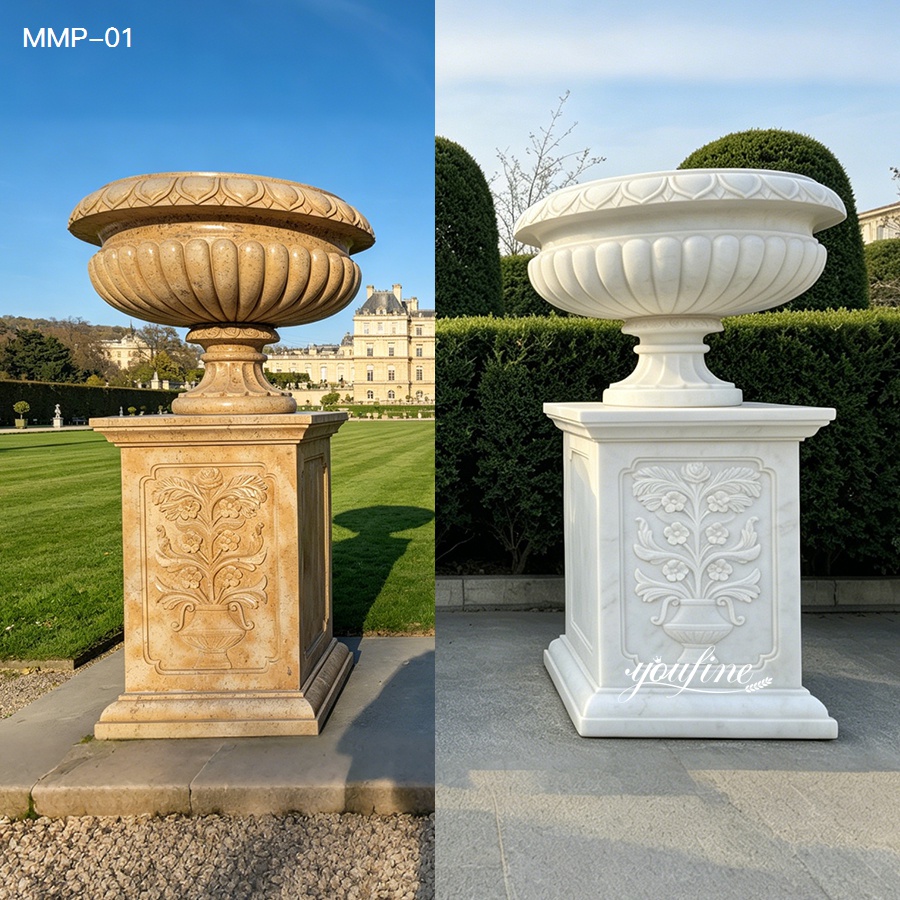 Pair of beige and white marble planters with ribbed bowls, set in a formal garden setting.