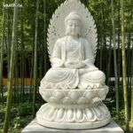 white marble buddha statue with carved backlight, meditating pose, lotus base, temple garden setting
