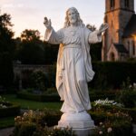 white marble Jesus statue displayed outdoors at sunset light