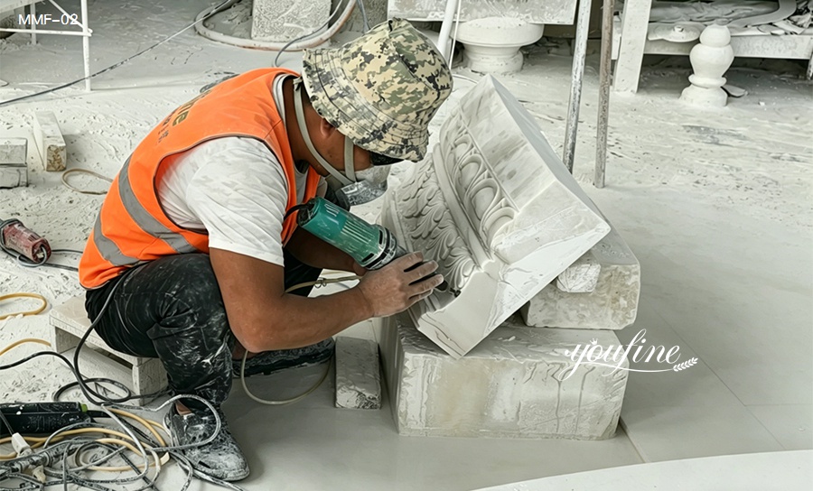 Skilled artisan hand-carving a marble fountain