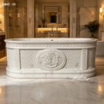 Premium hand carved marble bathtub with woven panel details set in warm luxury residential bathroom