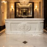 Freestanding hand carved marble bathtub with ornate front carving inside high-end marble bathroom space