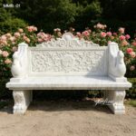 Solid white natural marble garden bench for sale with swan armrest, outdoor stone seating next to garden rose flowers