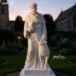 Outdoor marble St Francis of Assisi statue shown in evening light