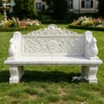 European style swan carved white marble garden bench for sale set on green grass beside colorful garden blooms