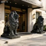 Two finely crafted black marble lion sculptures sit prominently at the entrance of a distinguished building, symbolizing strength and sophistication.