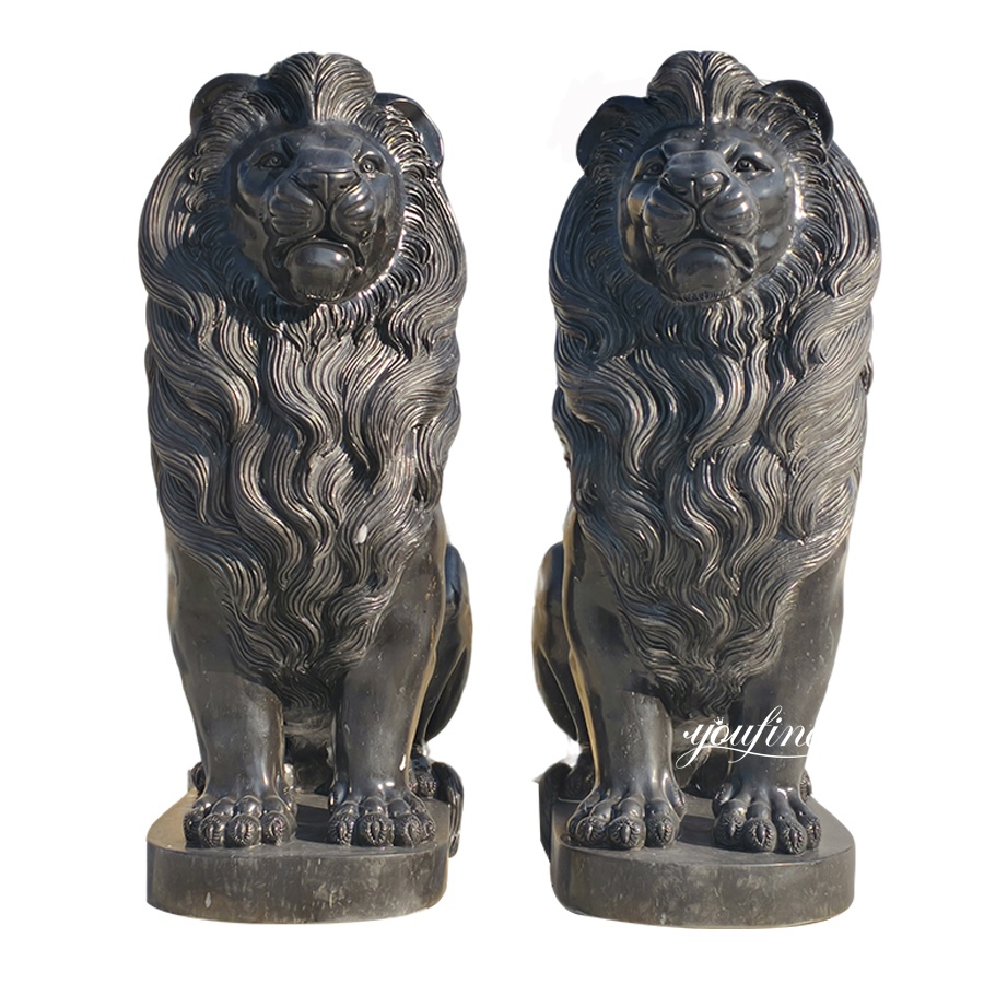A pair of intricately detailed black marble lion sculptures with flowing manes, seated on rectangular bases.