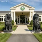 Two black marble lion statues majestically guard the entrance of a classical building surrounded by manicured landscaping.